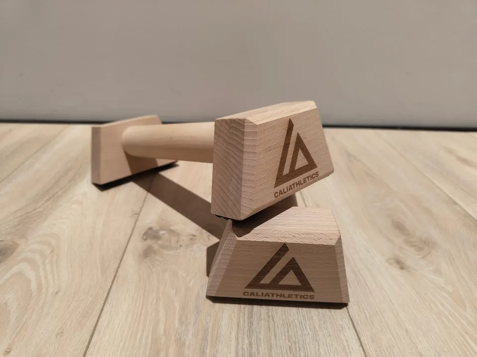 Wooden Parallettes Mini Caliathletics, la paire posée sur un parquet