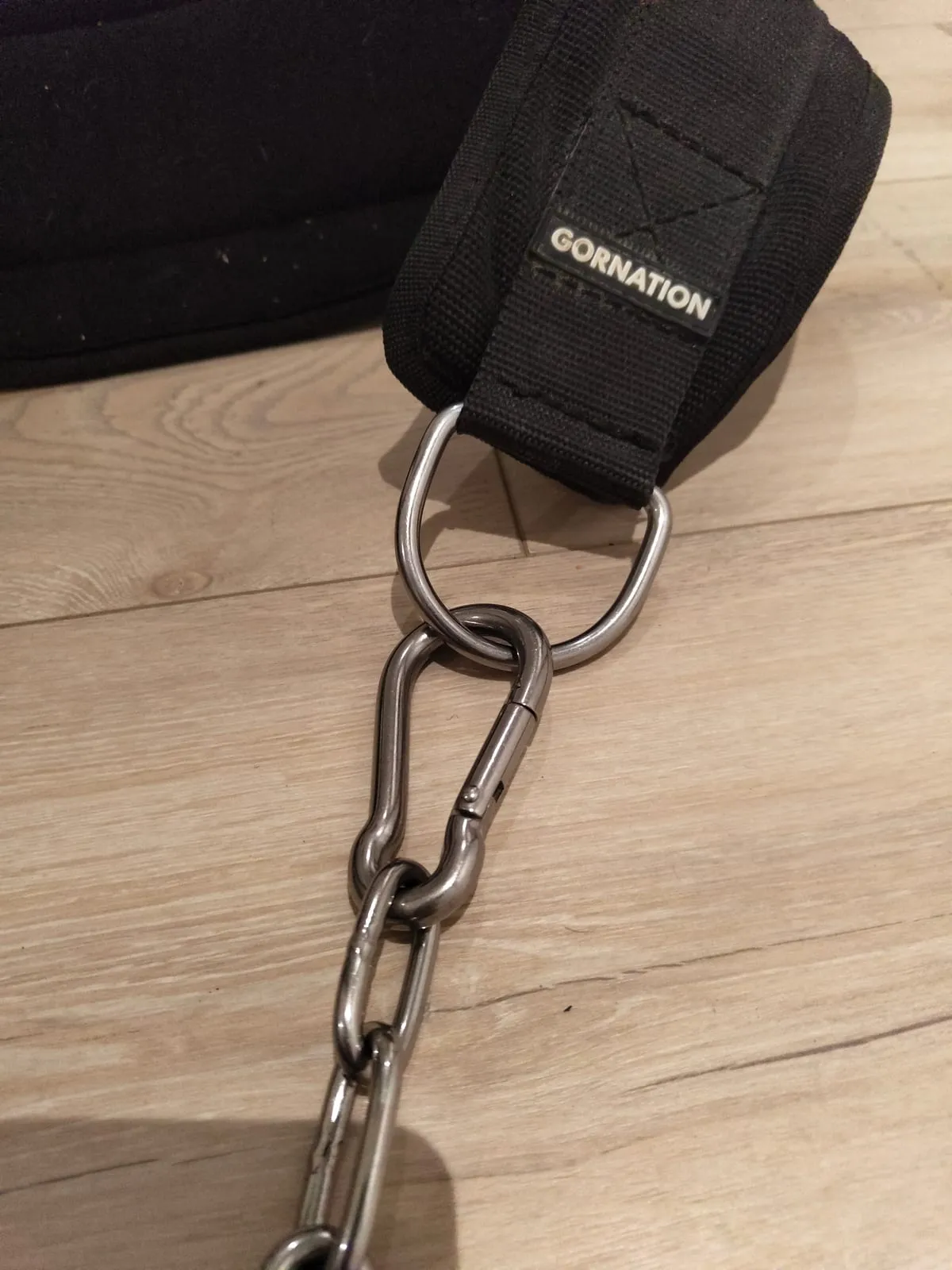 Spring carabiner clipped into the belt's D-ring, with the first links of the chain